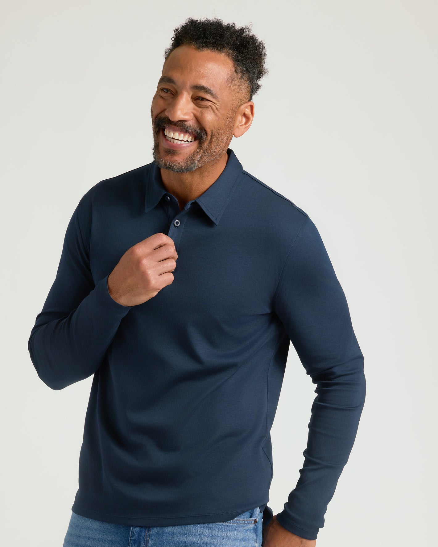 Man smiling in Navy Long Sleeve Premium Pima Polo and jeans.