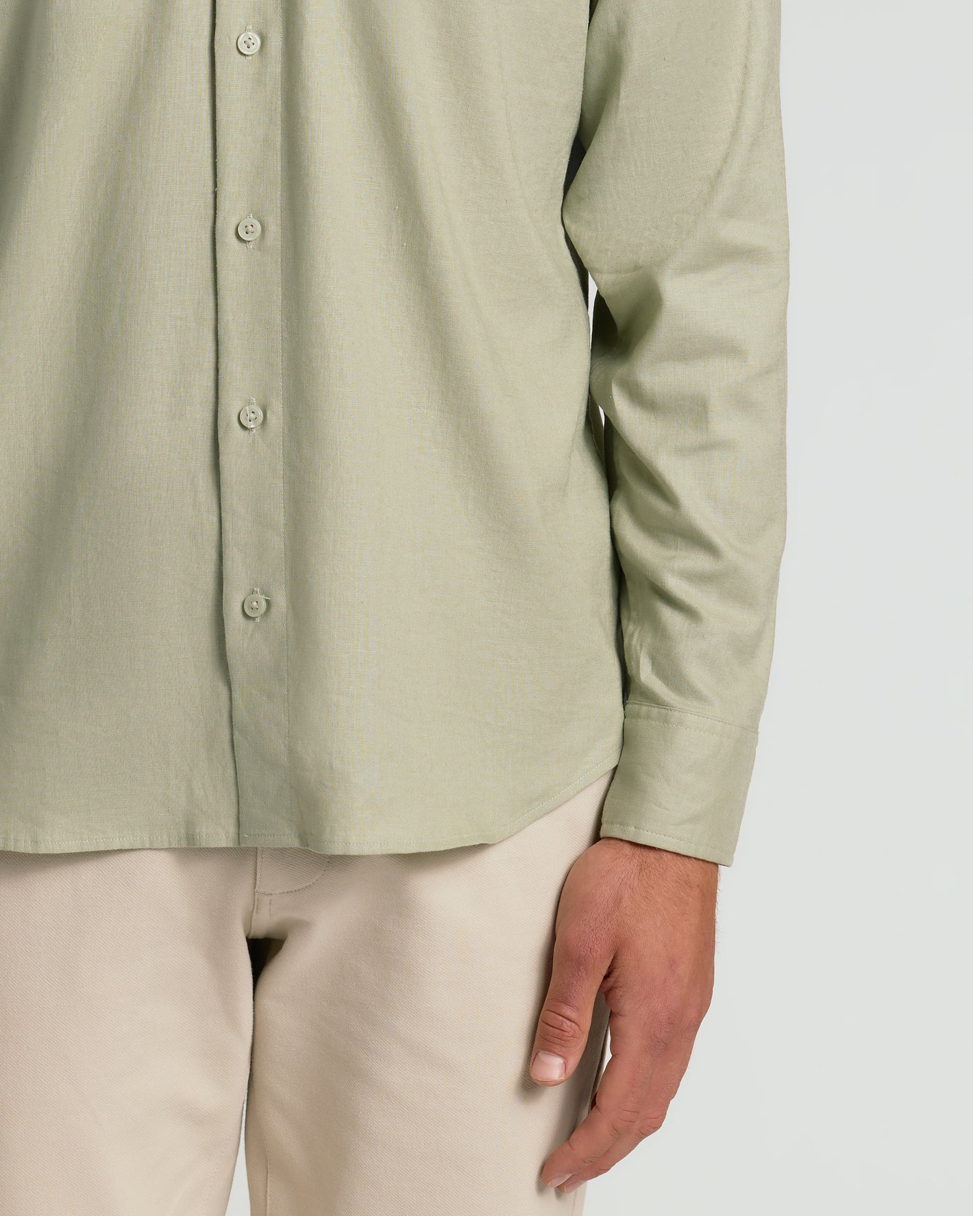 Mossy Oak Long Sleeve Linen Shirt, sage-green, worn with beige pants.