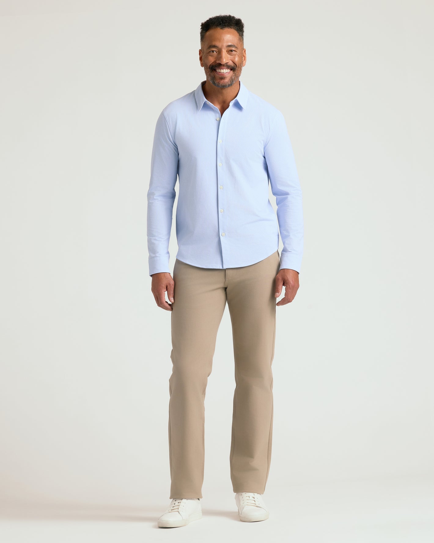 Man wearing Blue Stripe Stretch Oxford 2.0 shirt and beige trousers.