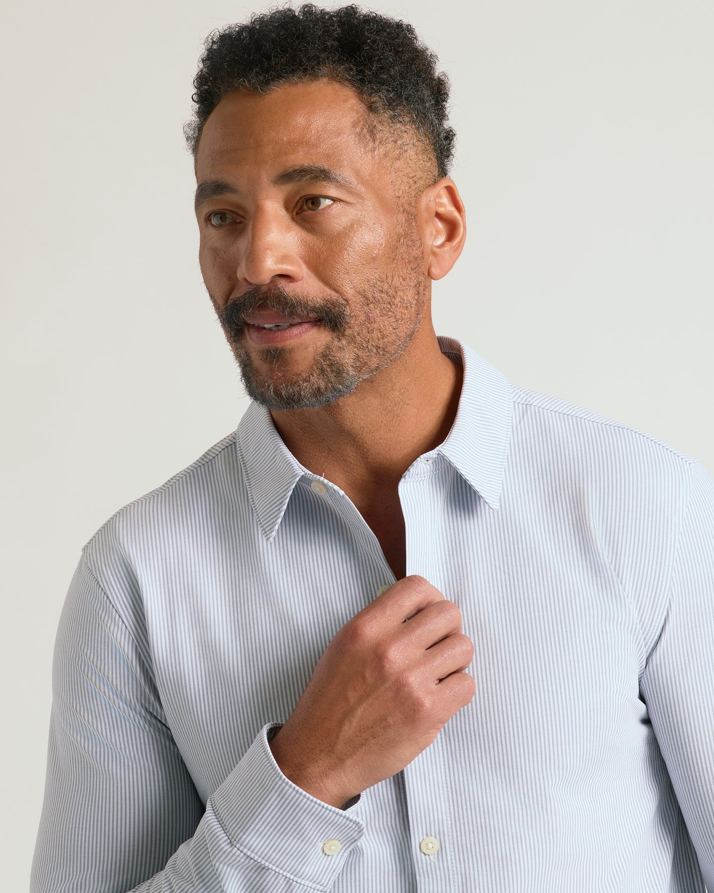 Man adjusting Steel Stripe Stretch Oxford 2.0 shirt collar.