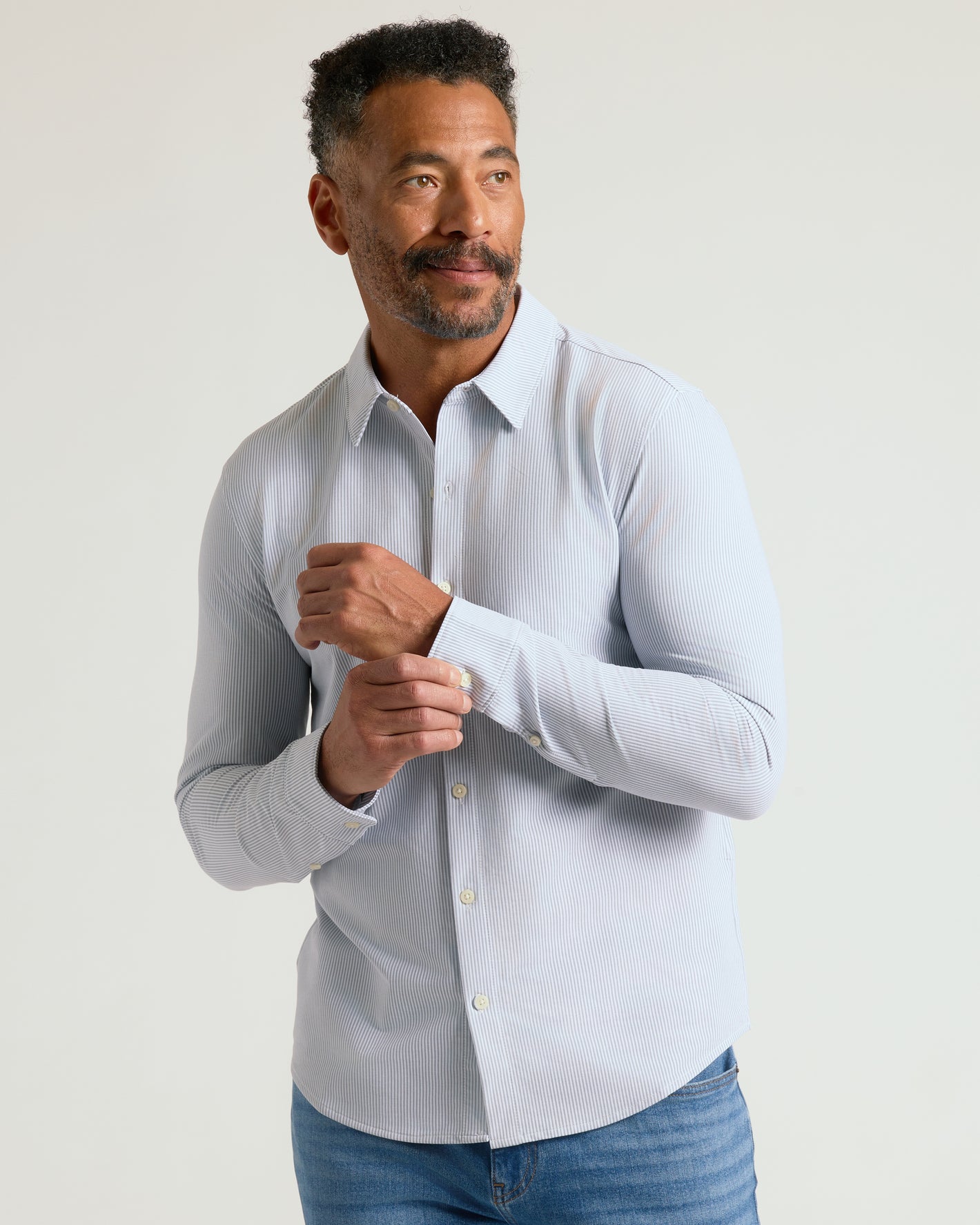 Man models Long Sleeve Stretch Oxford 2-Pack shirt, fastening cuff.