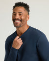 Man in a navy Premium Pima Long Sleeve Crew, smiling warmly.