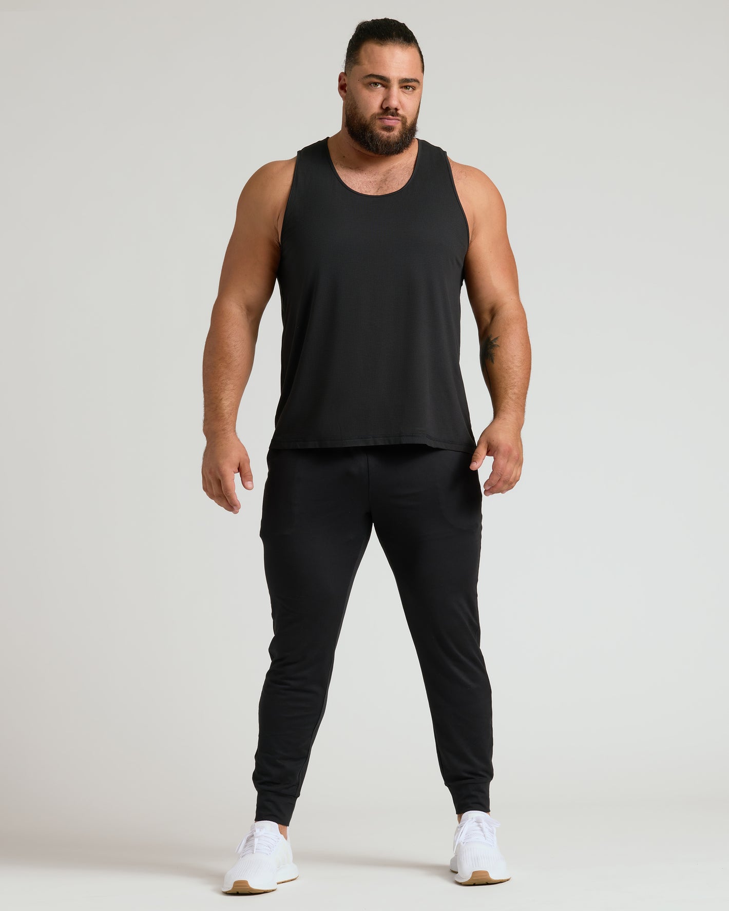 Man wearing Sleeveless Active Mesh Tank 3-Pack with joggers and running shoes.