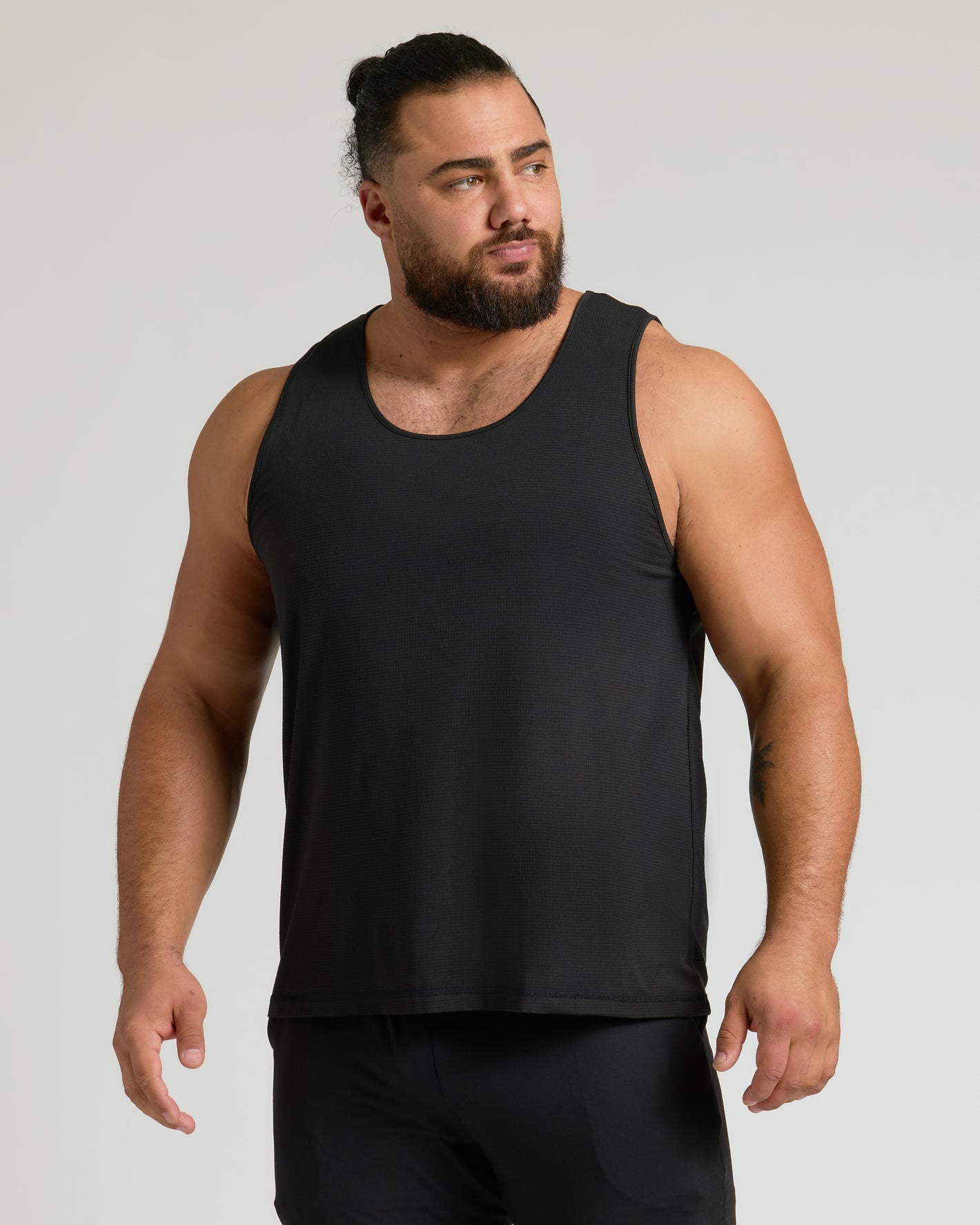 Man modeling Sleeveless Active Mesh Tank, showcasing athletic fit and breathable design.
