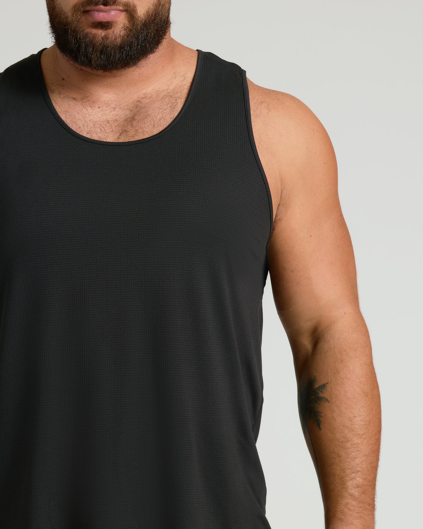 Black Sleeveless Active Mesh Tank showcasing breathable design on muscular build.