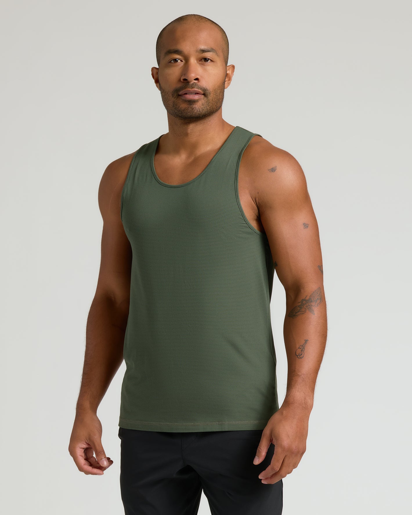 Man in olive-green Standard Sleeveless Active Mesh Tank, showcasing athletic fit and texture.
