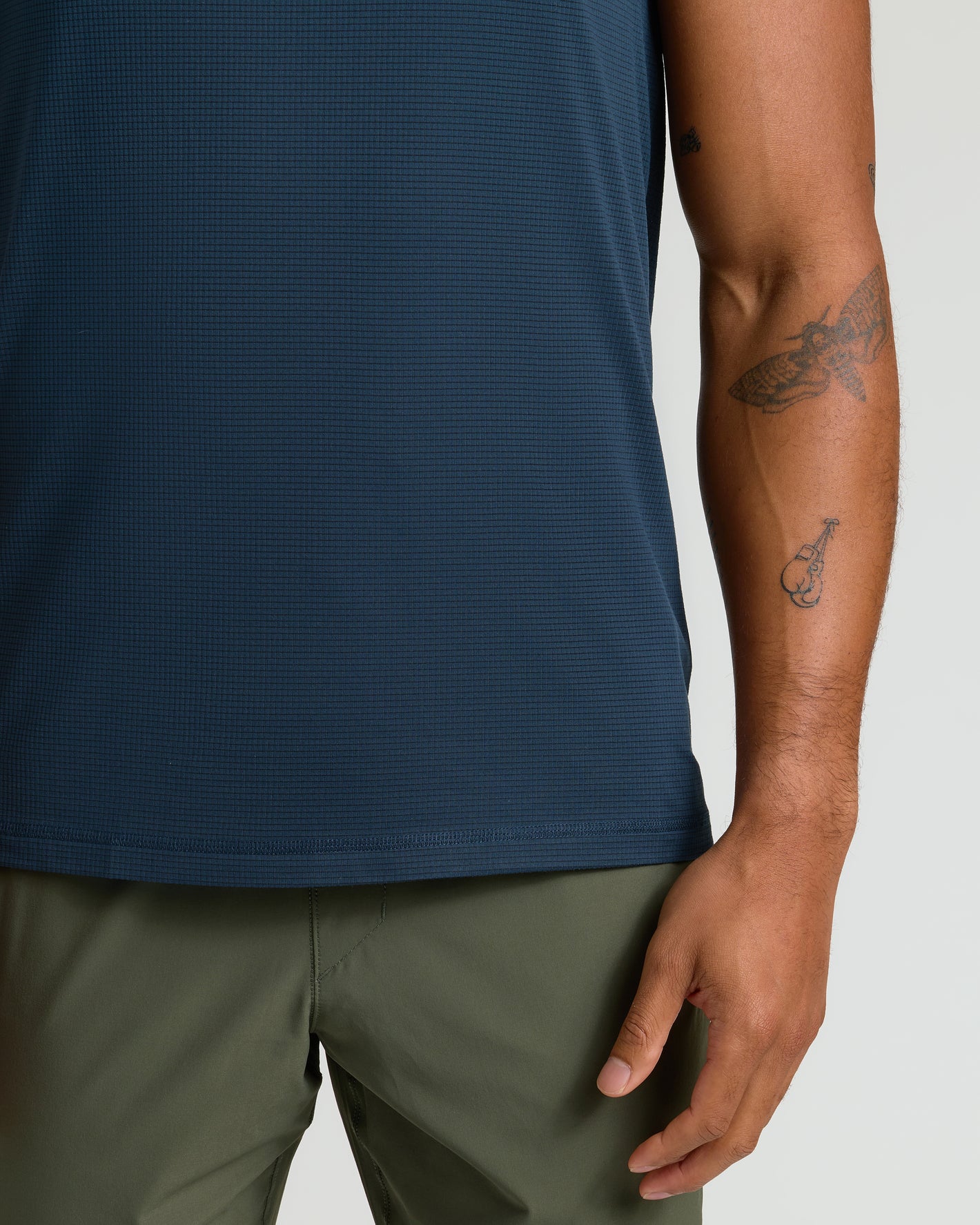 Navy Sleeveless Active Mesh Tank on model's midsection with tattoos.