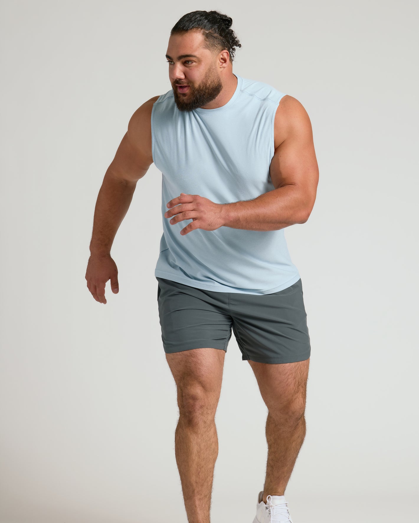 Man wearing Arctic Sleeveless Active Muscle Tee, poised to sprint.