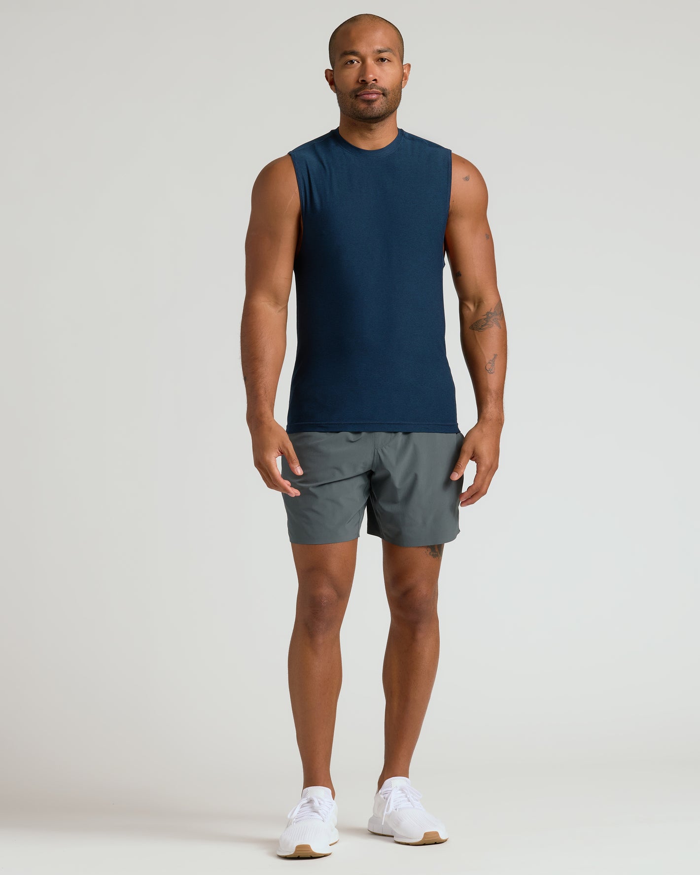 Man wearing Dark Heather Navy Sleeveless Active Muscle Tee in relaxed pose.