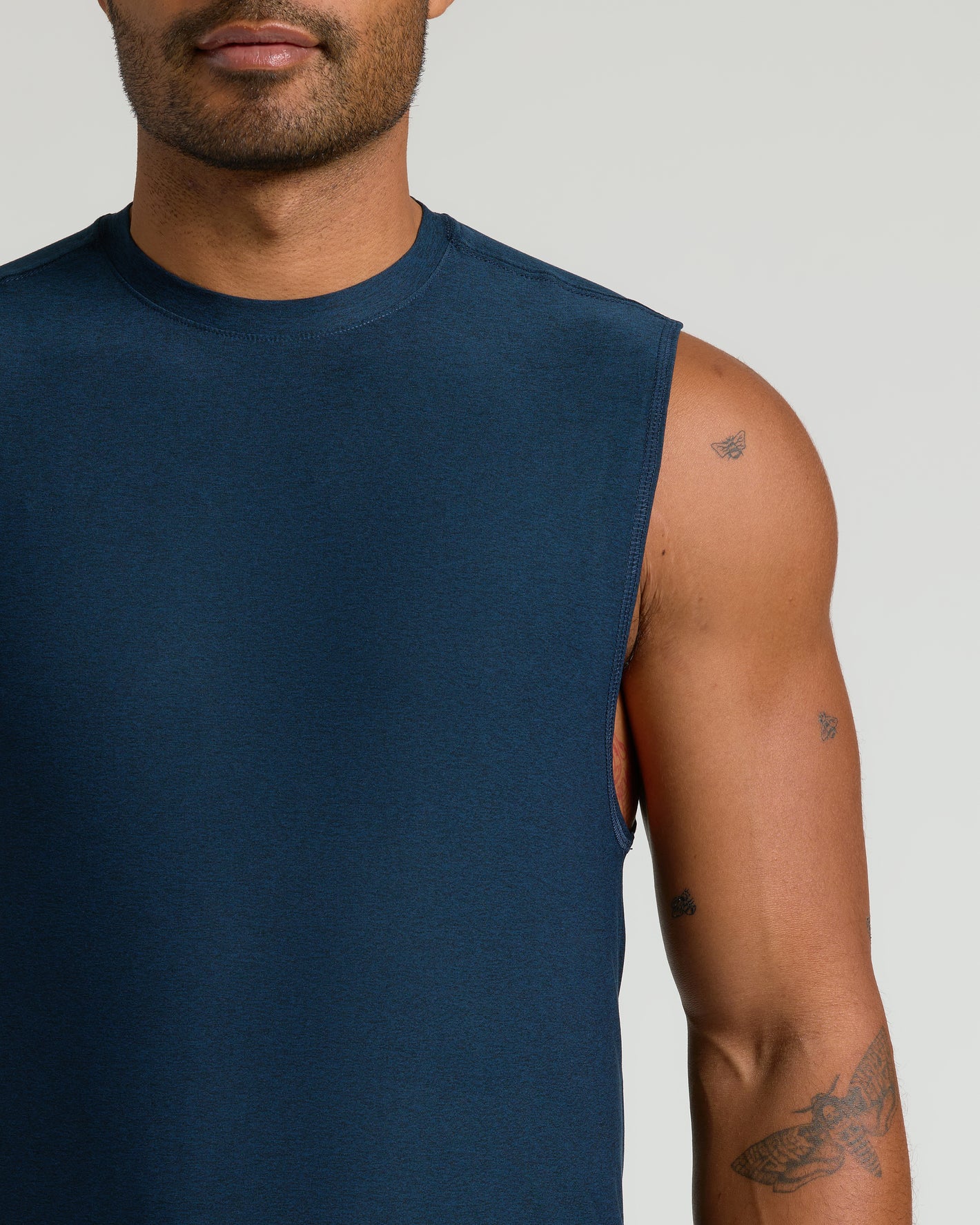 Man wearing Dark Heather Navy Sleeveless Active Muscle Tee, showcasing tattoos.