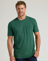 Man in Classic Pocket Crew 3-Pack, forest-green tee, relaxed smile.