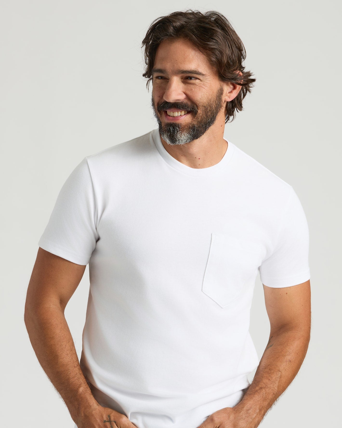 Man wearing All White Heavyweight Pocket Crew T-shirt, smiling.