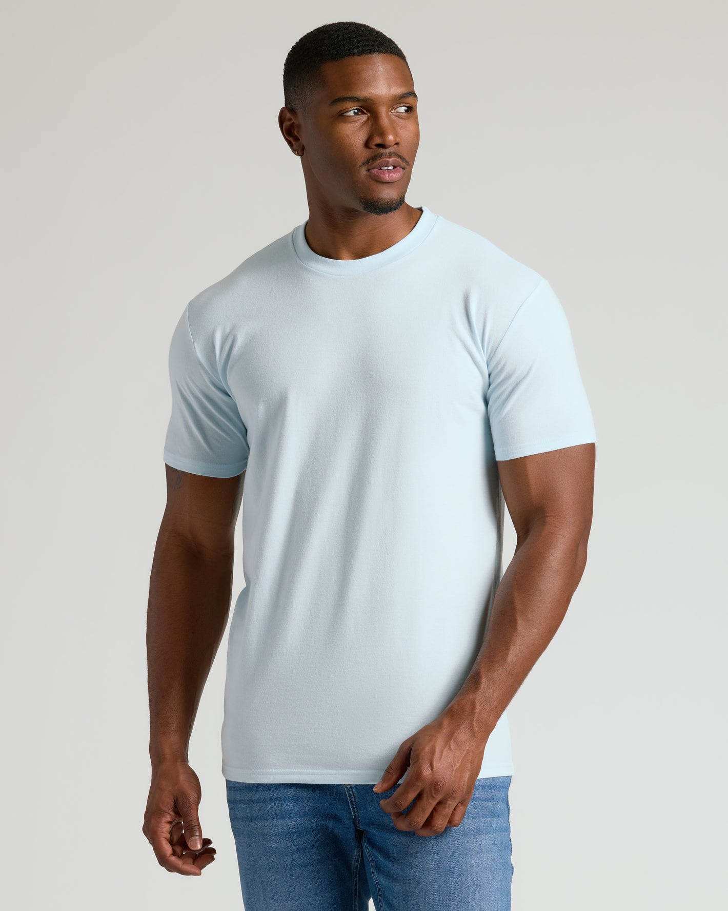 Male model in Seasonal Tall Straight Hem T-Shirt, pale blue, with blue jeans.