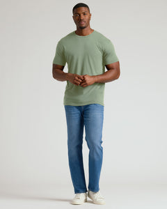 True ClassicMan wearing a green t-shirt and blue jeans on a white background