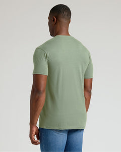 True ClassicMan wearing a green t-shirt and blue jeans on a light gray background