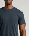 Man wearing a plain dark gray t-shirt against a neutral background