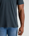Person wearing a dark gray t-shirt and blue jeans on a light gray background