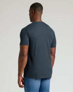 True ClassicMan wearing a dark gray t-shirt and blue jeans on a light gray background