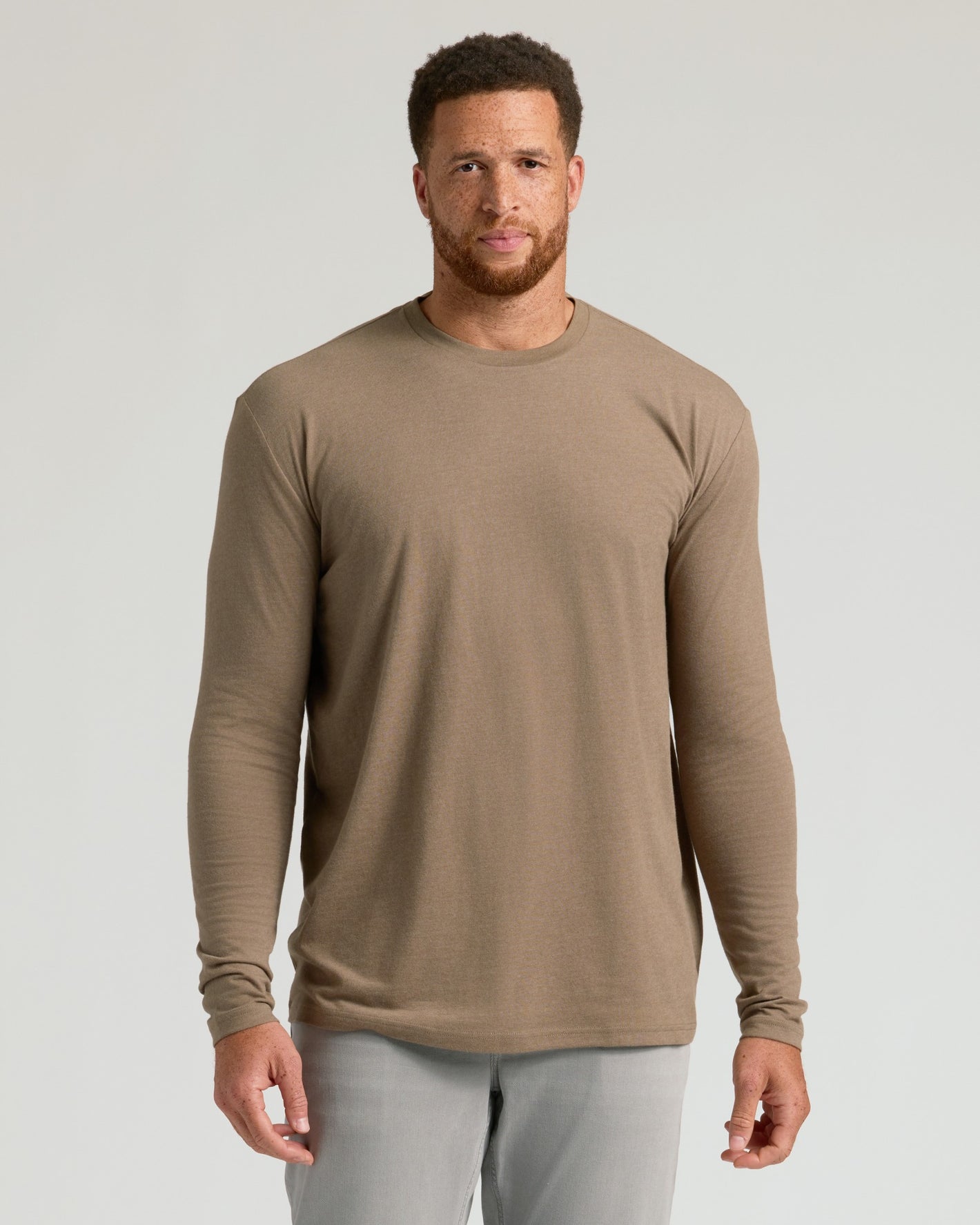 Man modeling Seasonal Tall Classic Long Sleeve Crew, taupe shirt, gray pants.