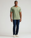 Man in Dark Heather Bay Green Tall Classic V-Neck, slim-fit jeans, sneakers.