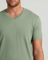 Man wearing a green V-neck t-shirt on a light gray background