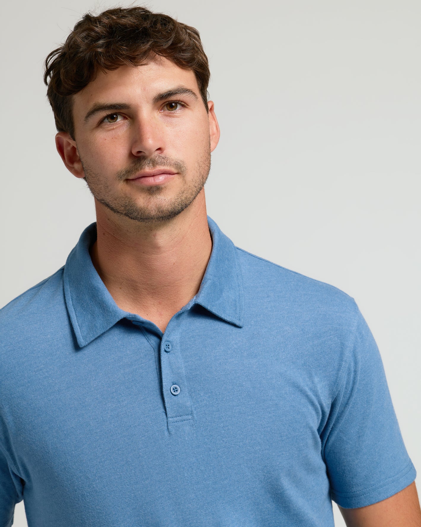 Young man wearing Dark Heather Blue Lake Short Sleeve Tall Polo.