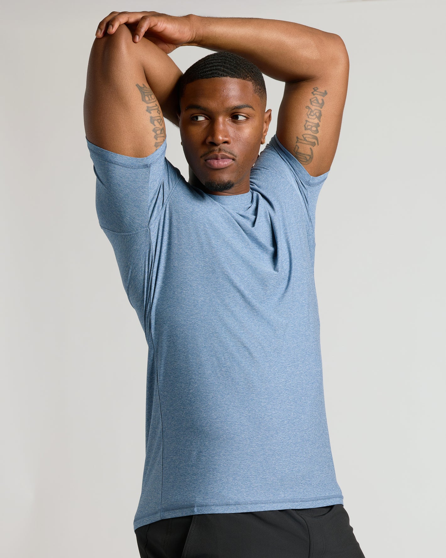 Heather Azul Tall Active Crew Neck 2.0 worn by fit man stretching.