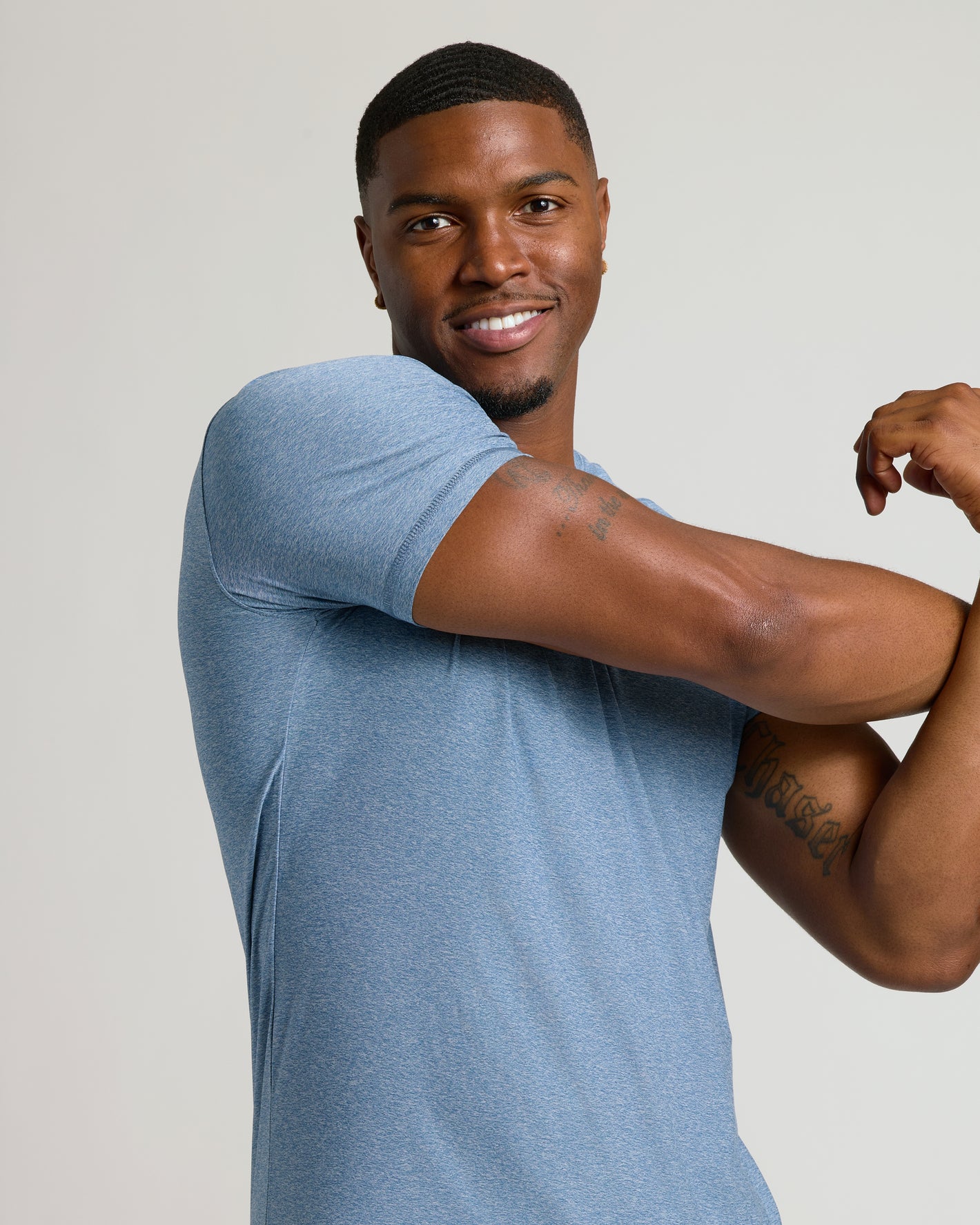 Heather Azul Tall Active Crew Neck 2.0 on muscular man flexing, smiling.