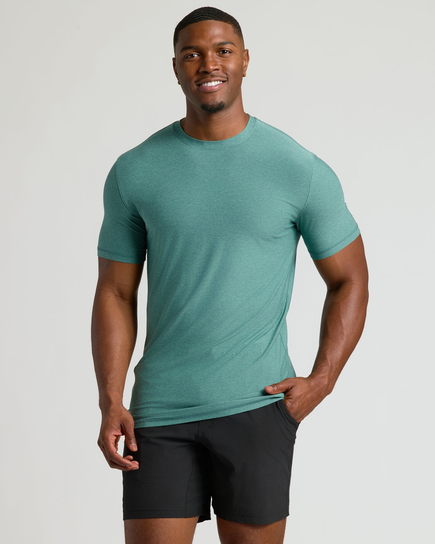 Fit young man in heathered green tee from Seasonal Tall Active Crew 3-Pack.