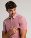 Young man wearing Quartz Rose Short Sleeve Tall Active Polo, checking sleeve fit.