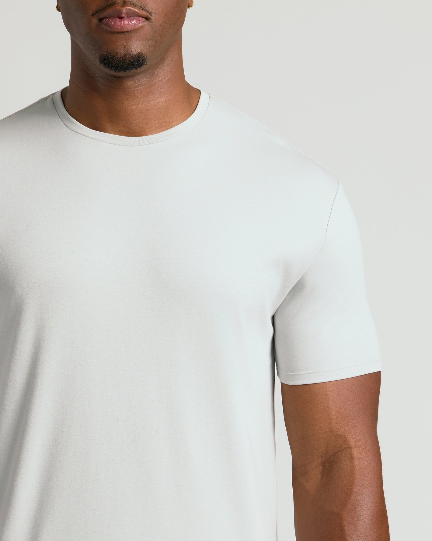Man wearing Seasonal Tall Premium Pima Crew Neck Tee, showcasing smooth, light-colored fabric.