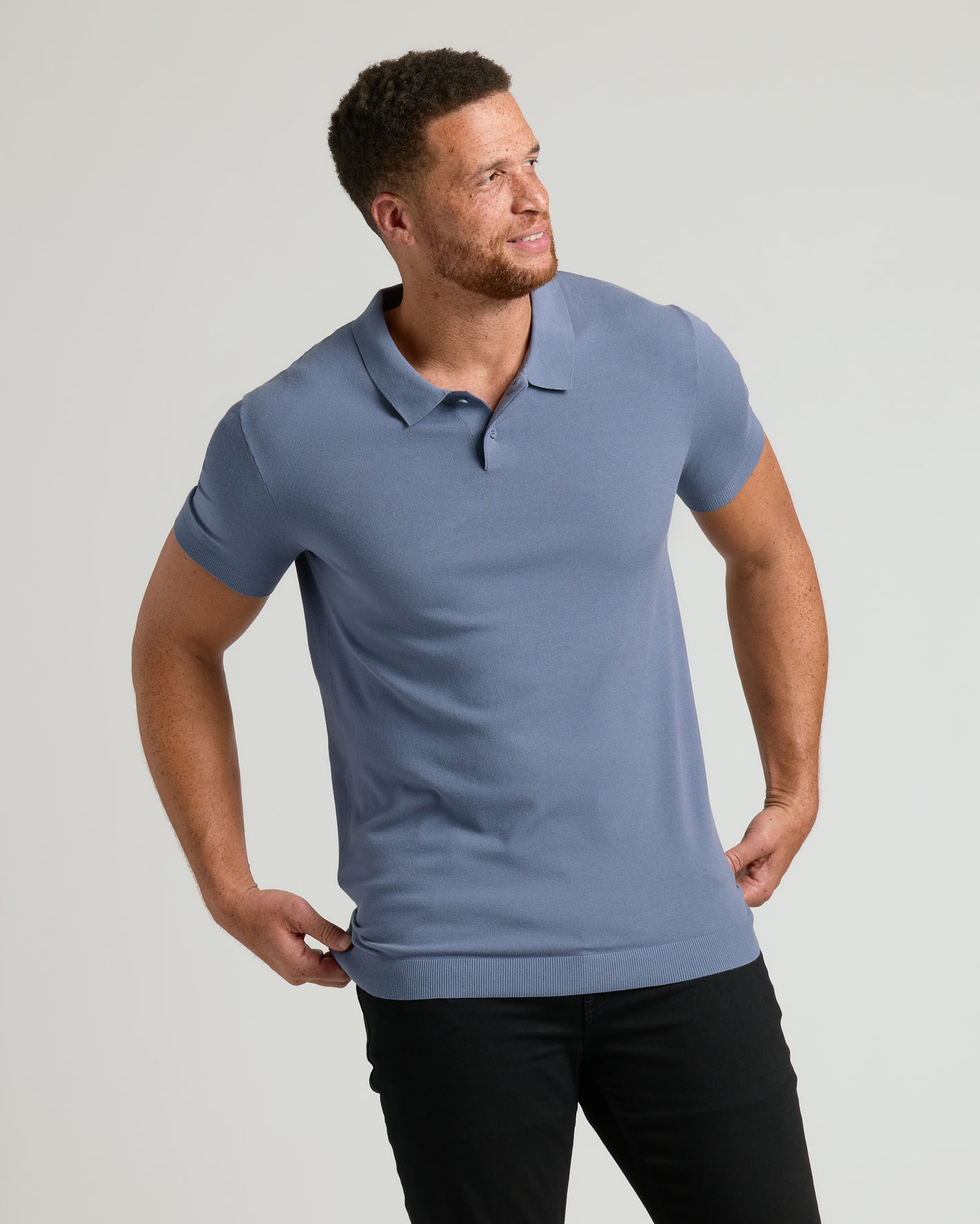 Man wearing a blue polo shirt against a gray background