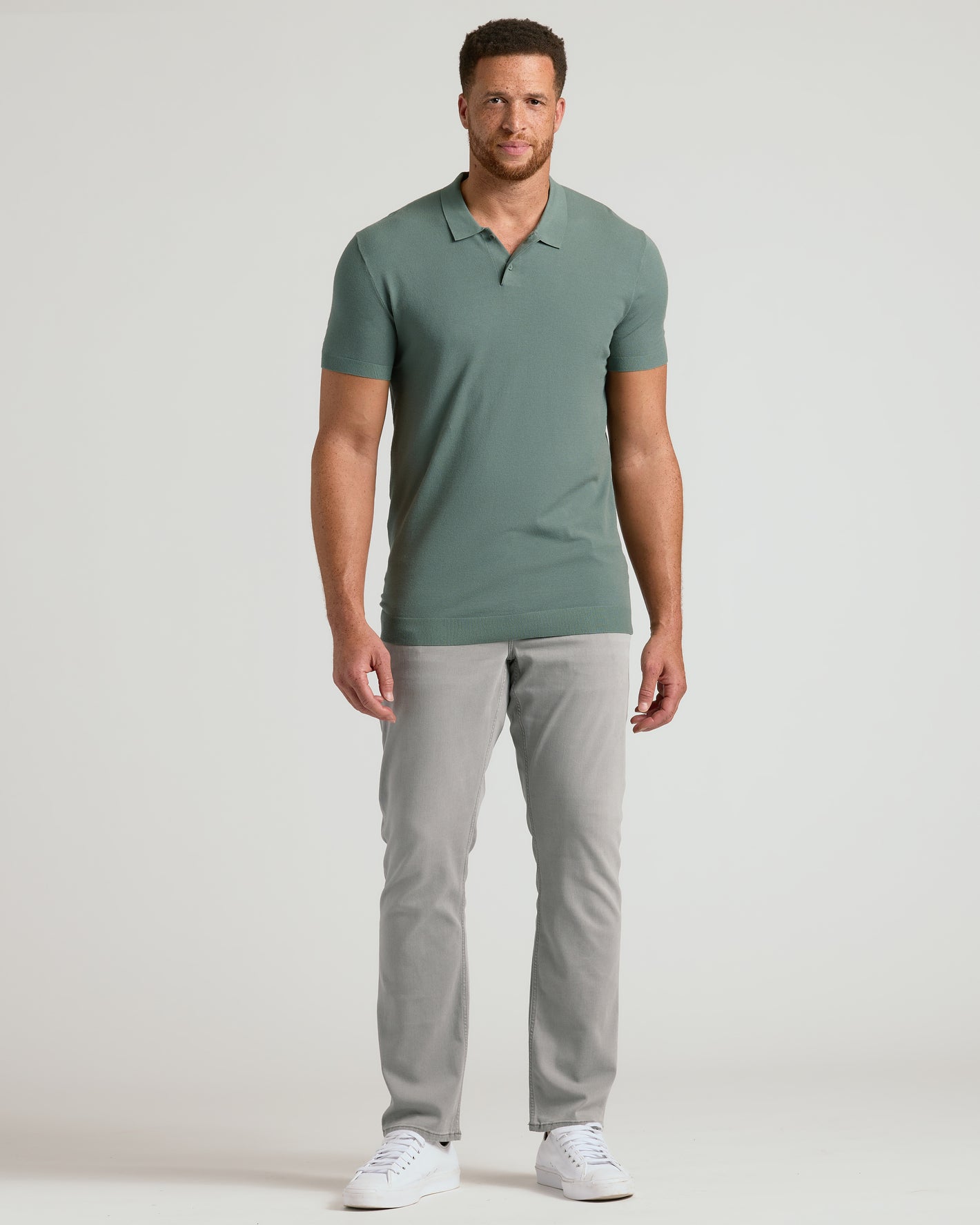 Man wearing Moss Tall Dressy Polo with light gray trousers and white sneakers.