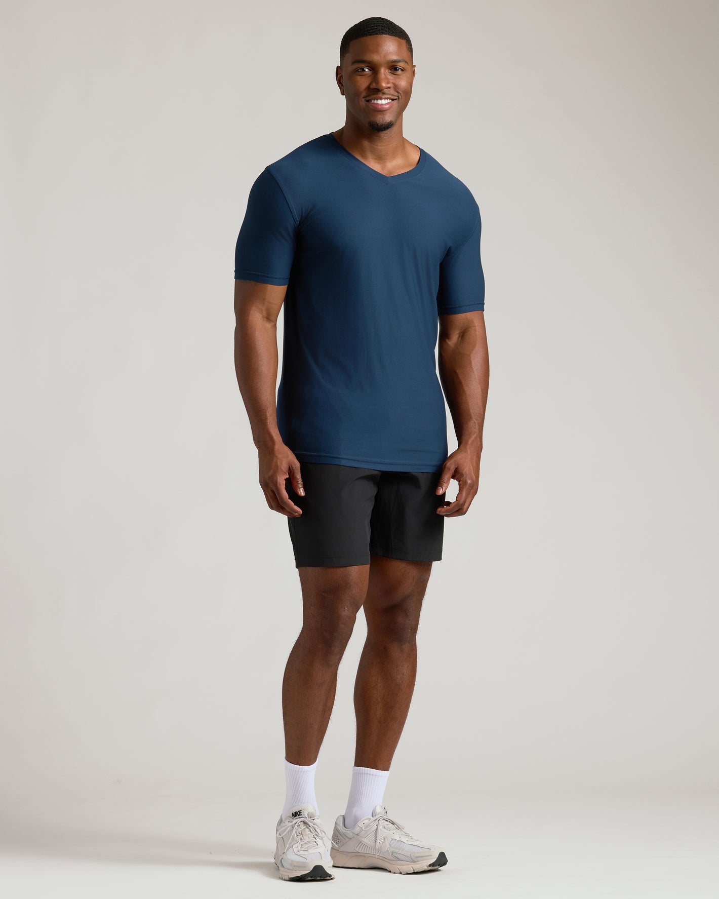 Man wearing Navy Tall Active V-Neck, black shorts, white socks, Nike shoes.
