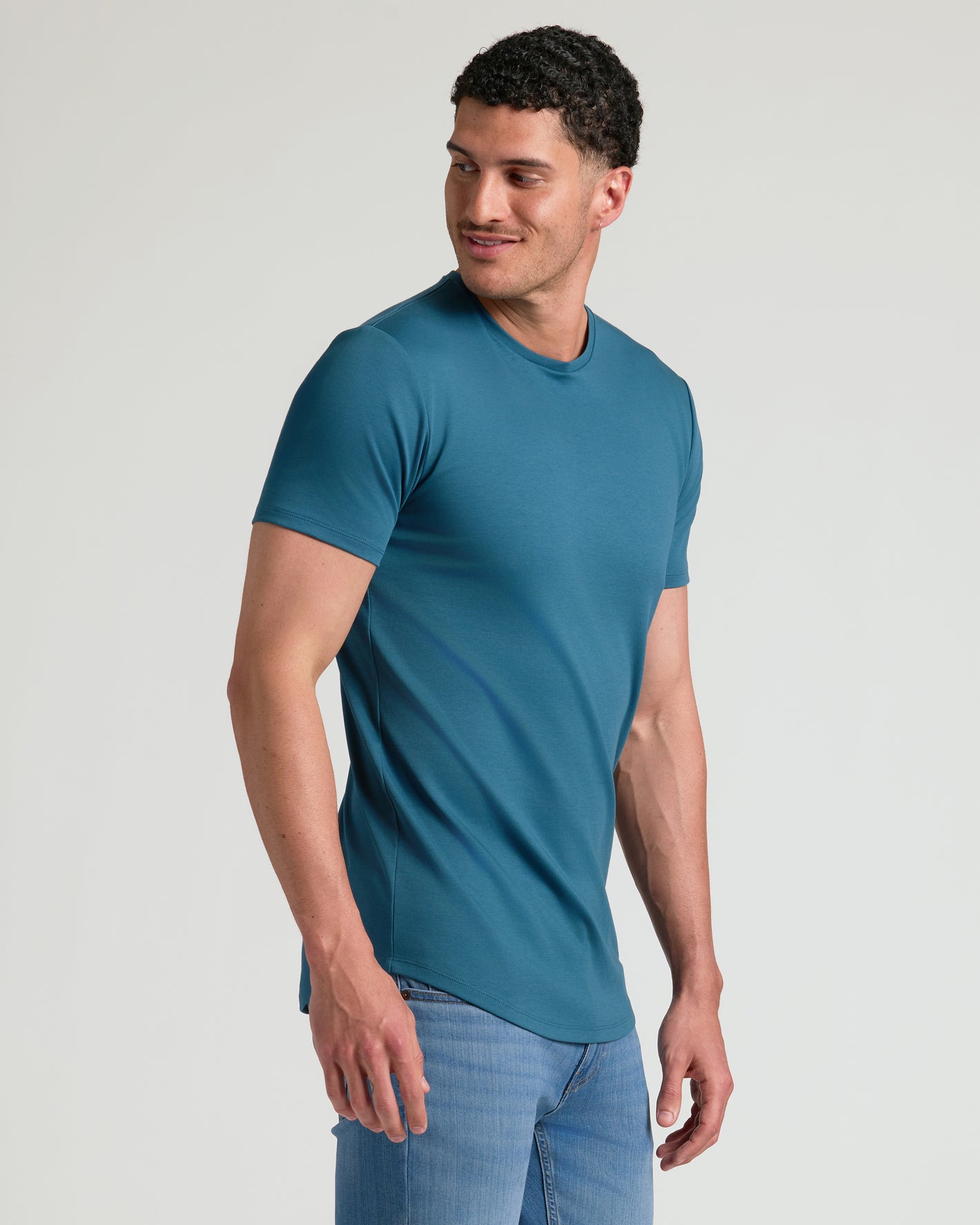 Man in Lagoon Tall Premium Pima Crew Curved Hem and jeans.