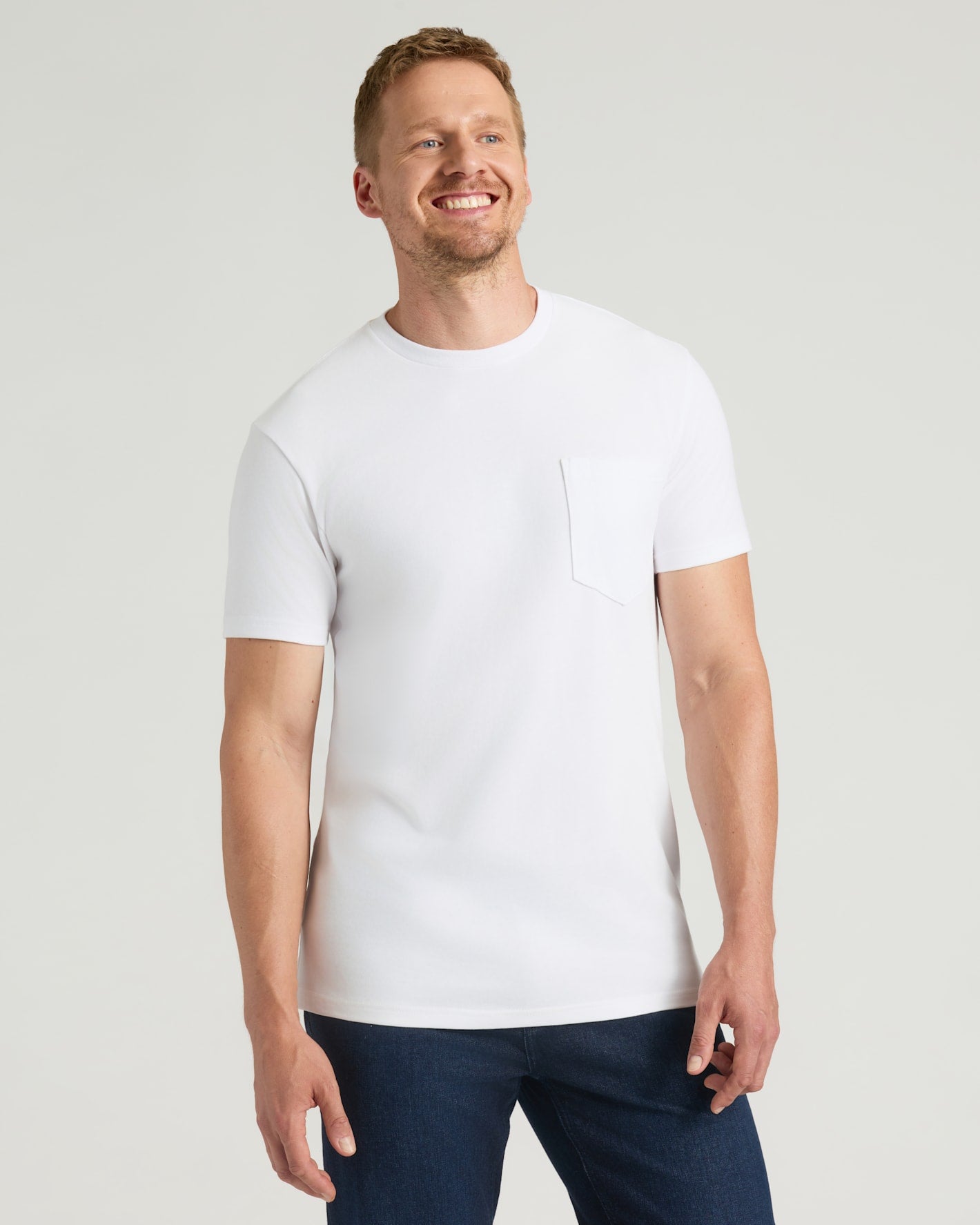 White Tall Heavyweight Pocket Crew worn by man in jeans, smiling.
