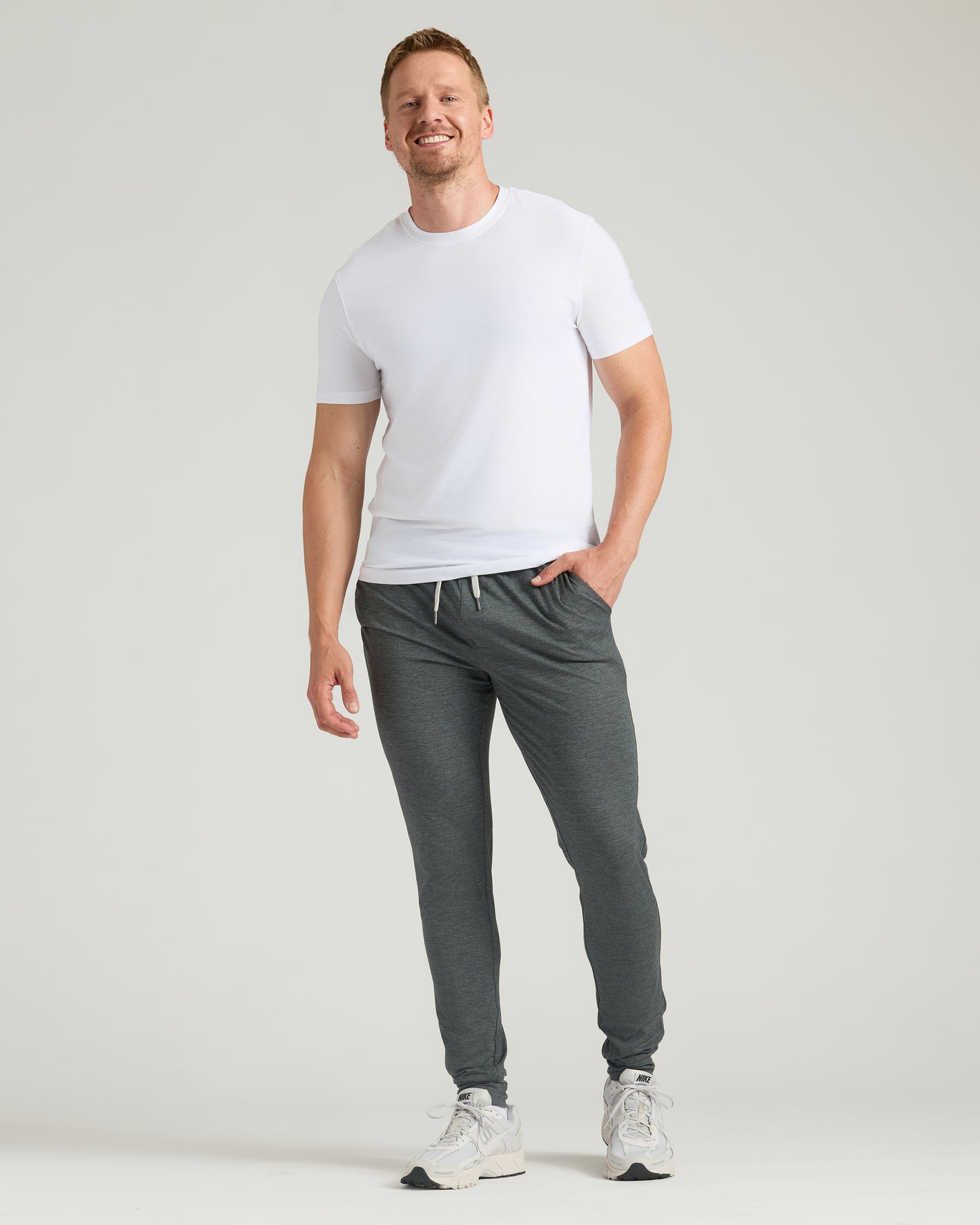 Tall man in Black & Charcoal Heather Gray Tall Active Joggers 2-Pack, smiling.