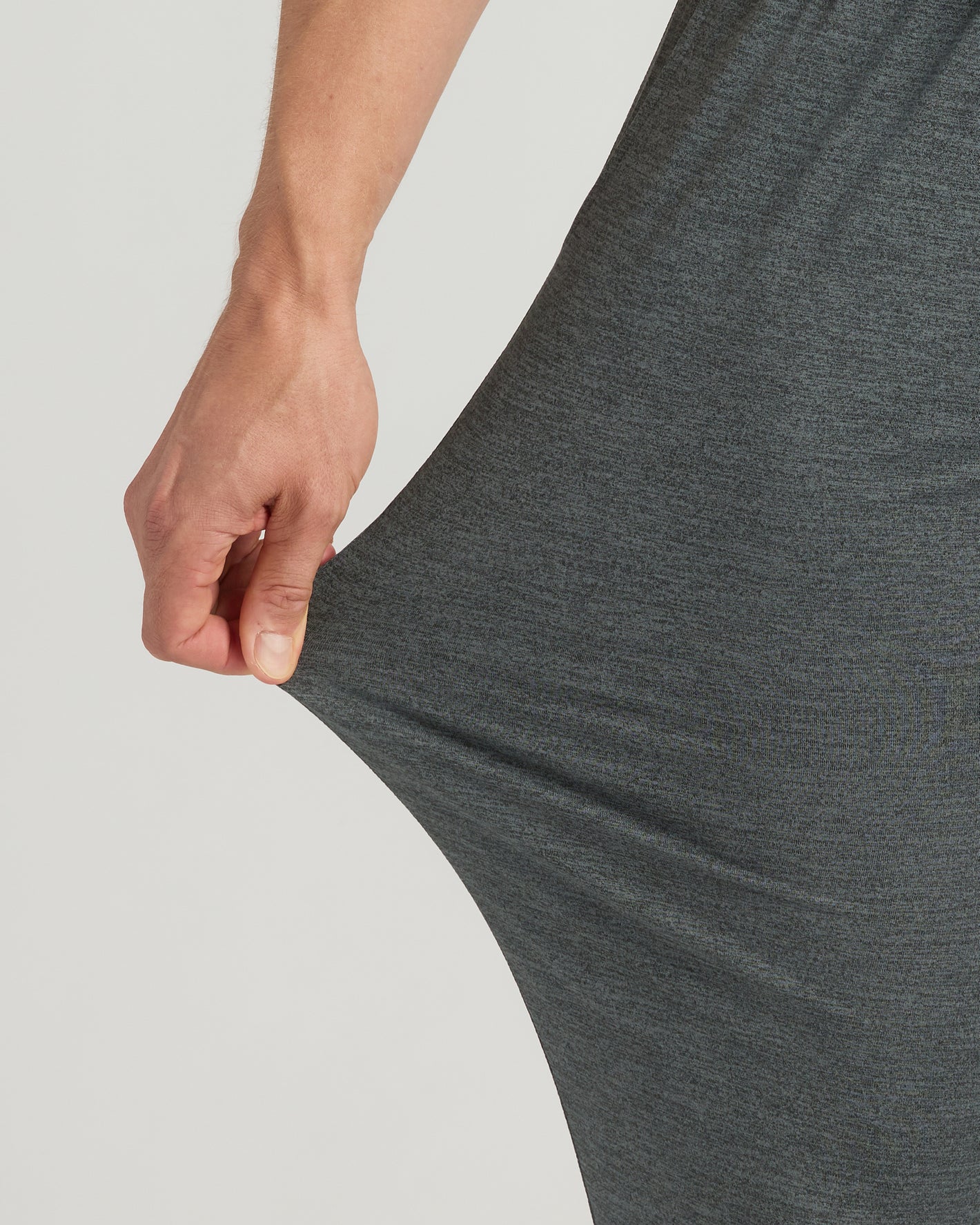 Hand pulling Charcoal Heather Gray Tall Active Joggers' stretchy, soft knit fabric.