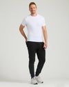 Man in Black Tall Fleece French Terry Joggers, relaxed pose.