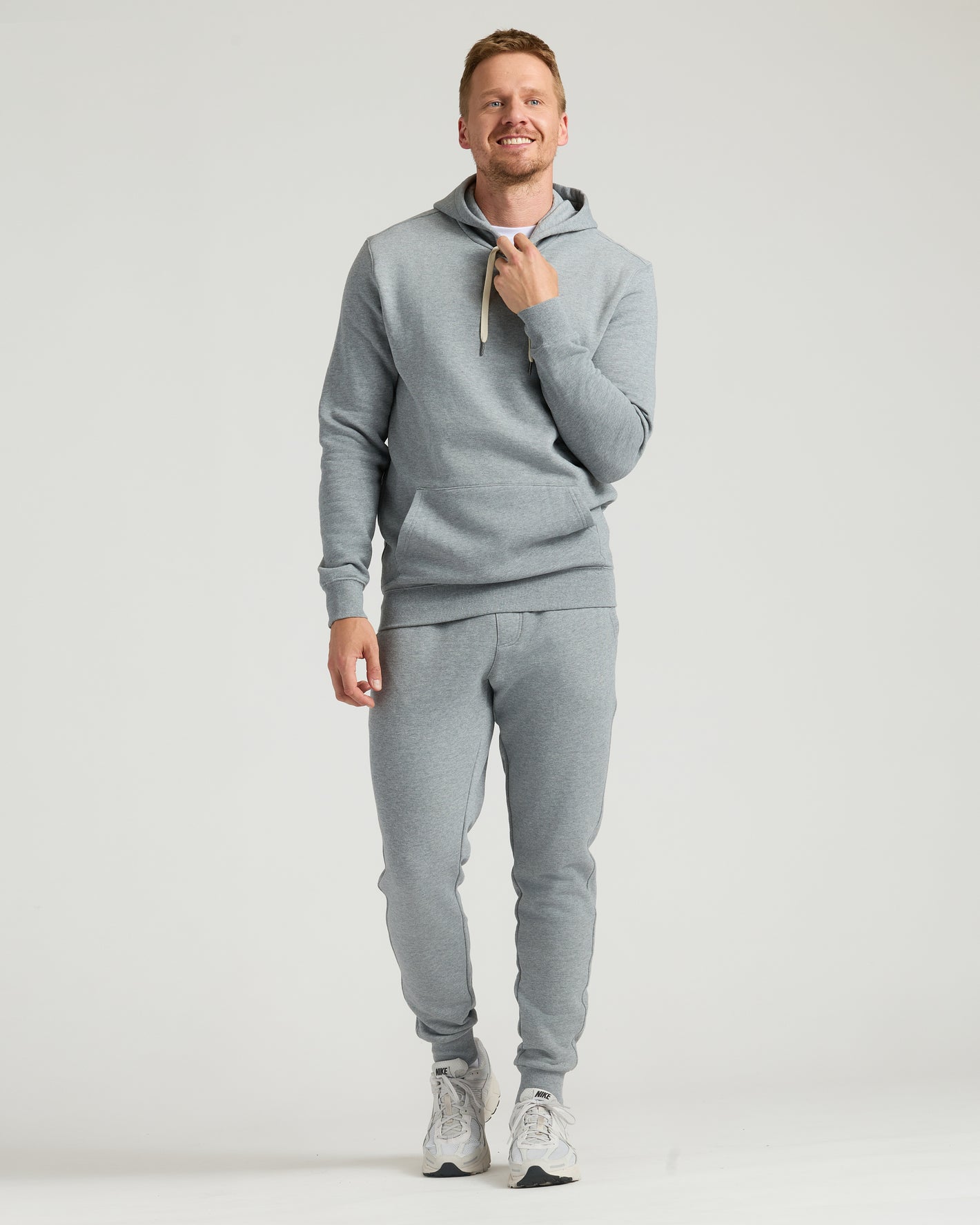 Man wearing Medium Heather Gray Tall Fleece Pullover Hoodie & Joggers 2-Pack.