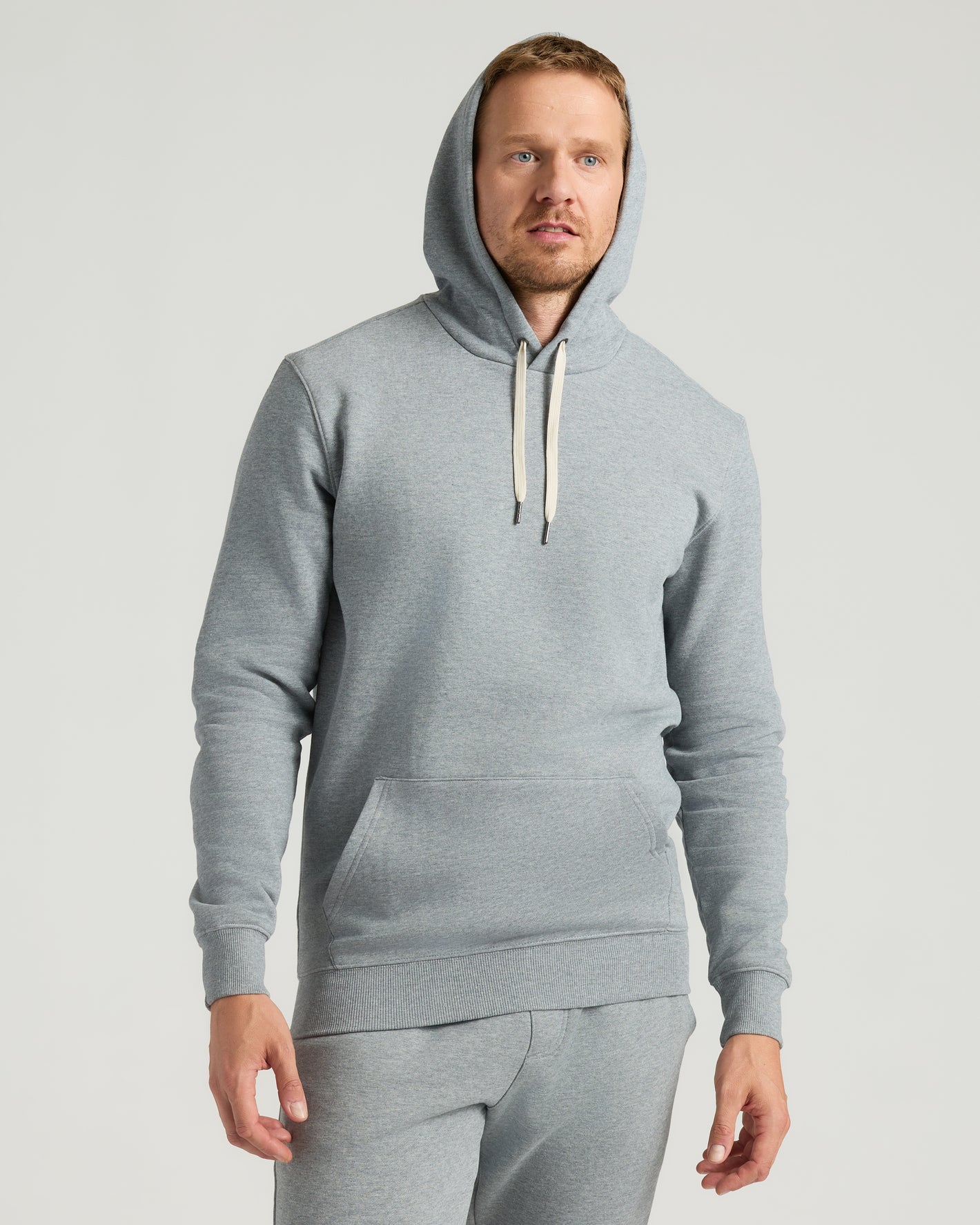 Man in Medium Heather Gray Tall Fleece Pullover Hoodie & Joggers.