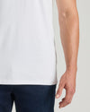Person wearing a plain white t-shirt and dark pants on a light background