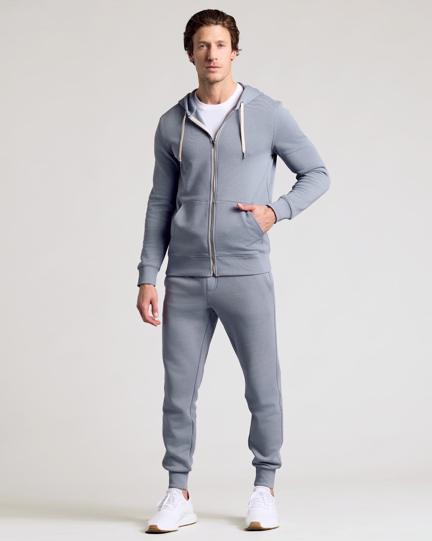 Man models Dusty Blue Fleece French Terry Zip Hoodie, hands in pocket.