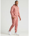 Man wearing Rose Fleece French Terry Pullover Hoodie, mid-step, smiling.