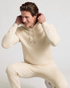 Man wearing Dune Fleece French Terry Pullover Hoodie, adjusting hood.