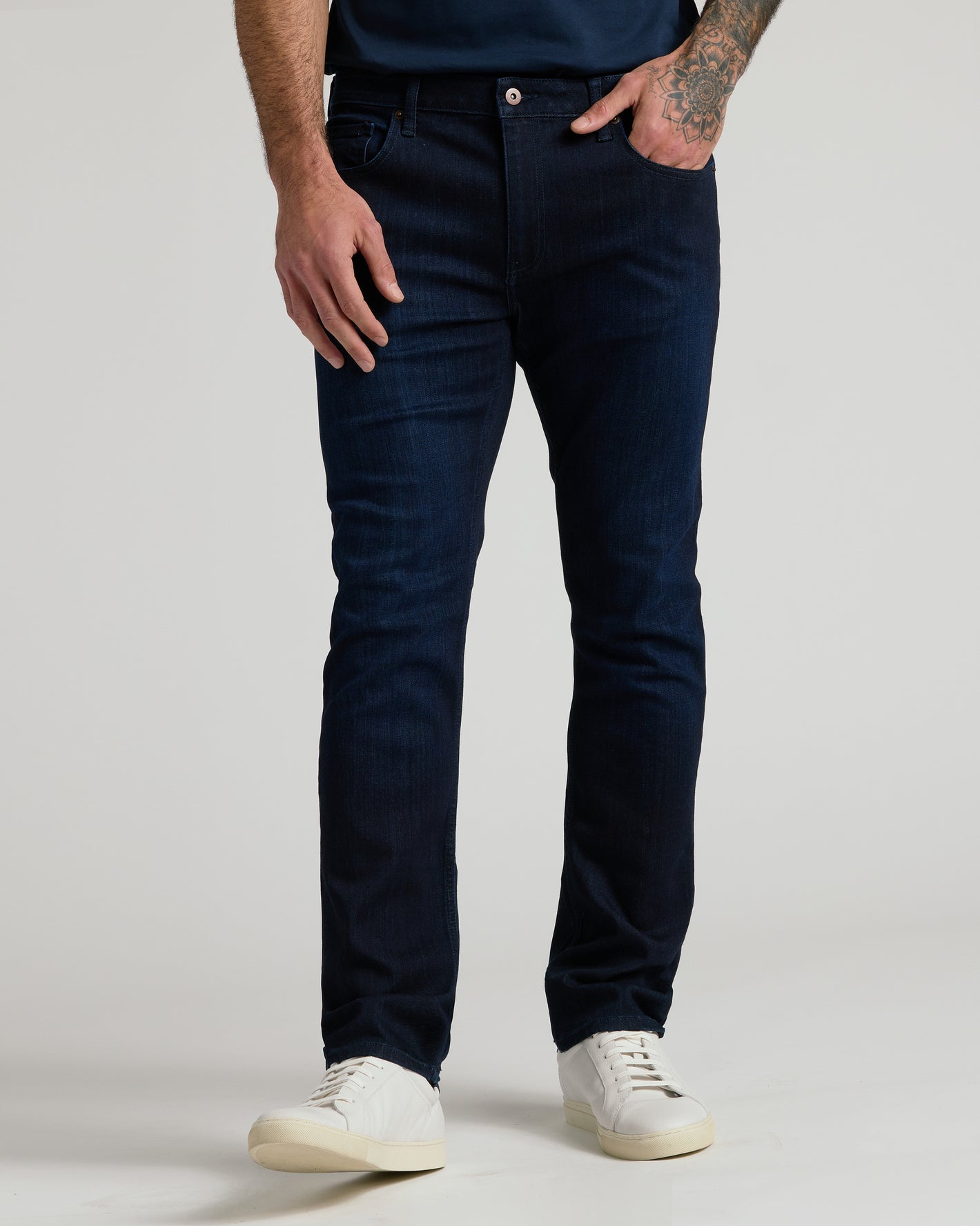 The Refined Ripstop Look: Indigo slim-fit jeans with white sneakers.