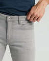 Medium Gray Wash Slim Comfort Stretch Jeans with hand on waistband.