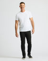 Man wearing a white t-shirt and black pants on a white background