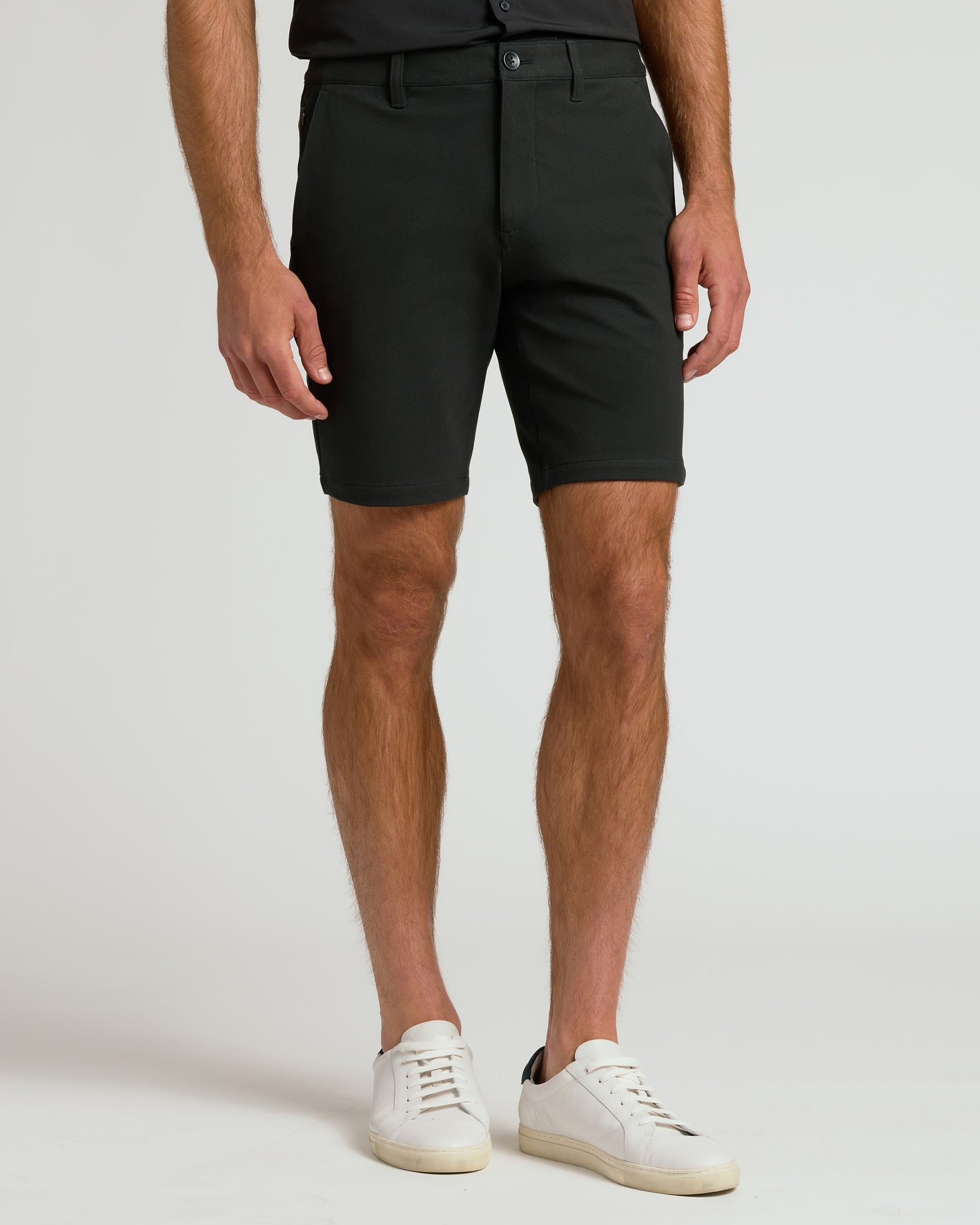 Model wearing The Standard 9 Chino Shorts, slim-fit, knee-length, with sneakers.