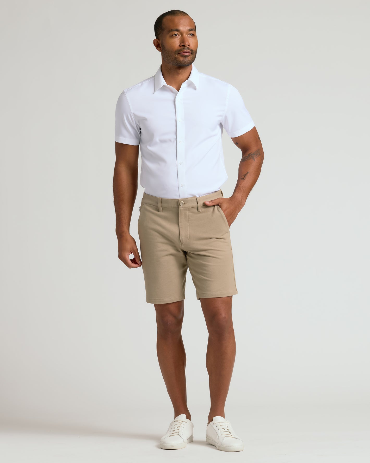 Man wearing 9 Khaki Chino Shorts 2.0, white shirt, white sneakers.